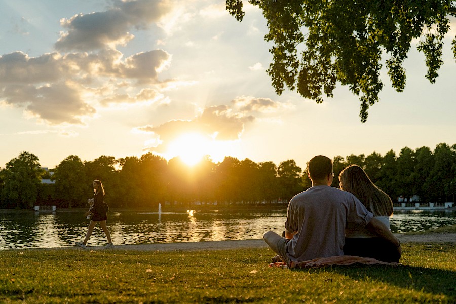 Auf der Wiese vor dem Biergarten lässt sich der Sonnenuntergang über dem Aachener Weiher besonders gut genießen | Die Kölner Parkweiher – Eine grüne Oase mitten in der Stadt