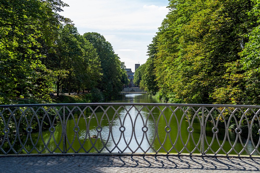 Blick von der Brücke in Richtung der Katholischen Pfarrkirche Christi Auferstehung von Gottfried Böhm | Die Kölner Parkweiher – Das Wasser führt den Blick