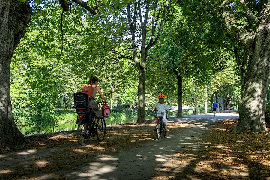 Fahrradfahrerin und Kind fahren mit dem Fahrrad am Clarenbachkanal