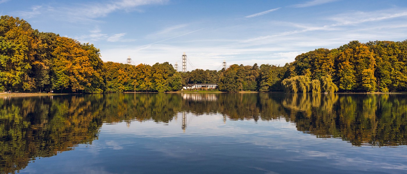 Adenauer Weiher mit Club Astoria und den Pylonen des Rhein-Energie-Stadions im Hintergrund
