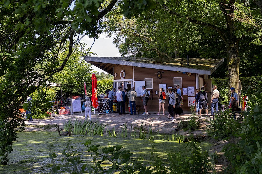 Mehrere Parkbesucher stehen Schlange an der Kahnstation
